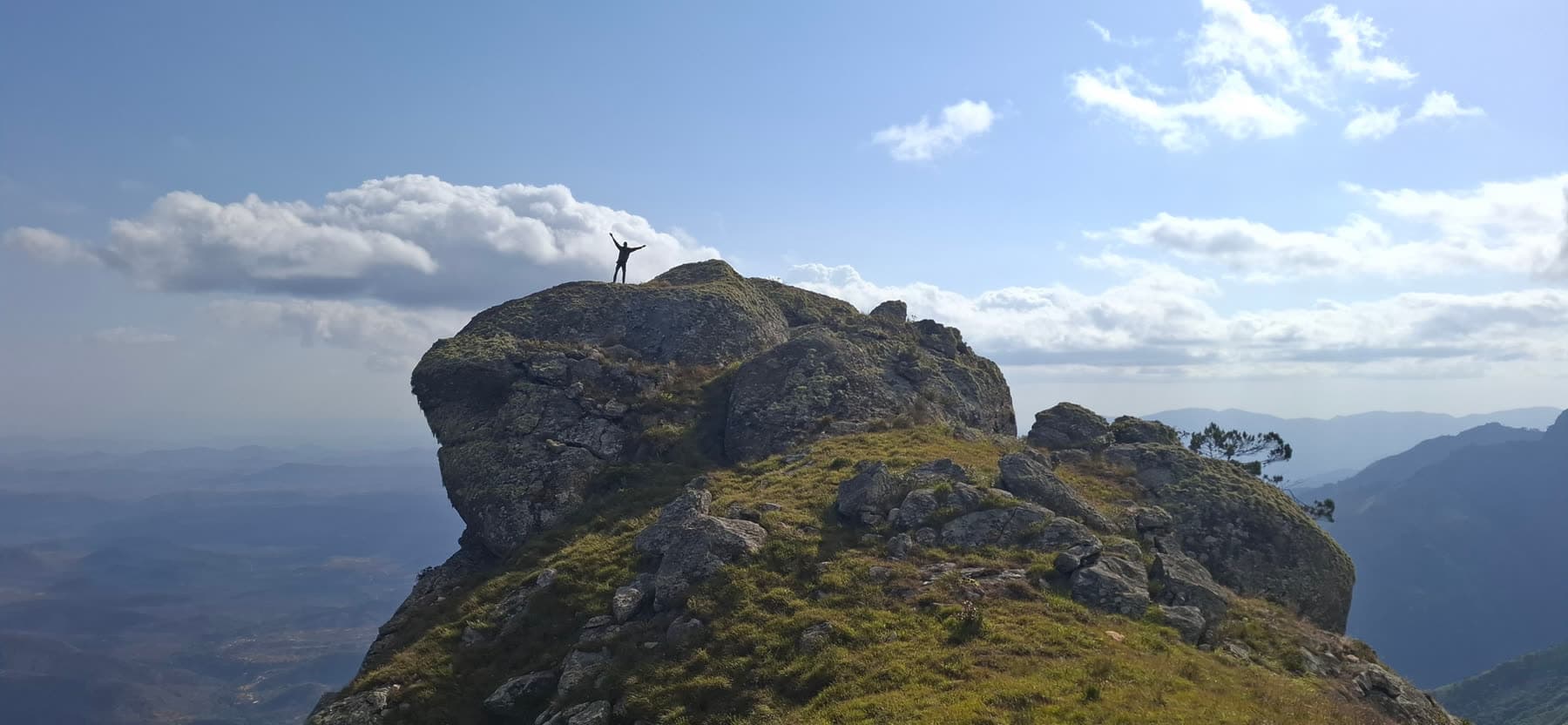 A trekker celebrating on a rocky Ndoto Mountains summit