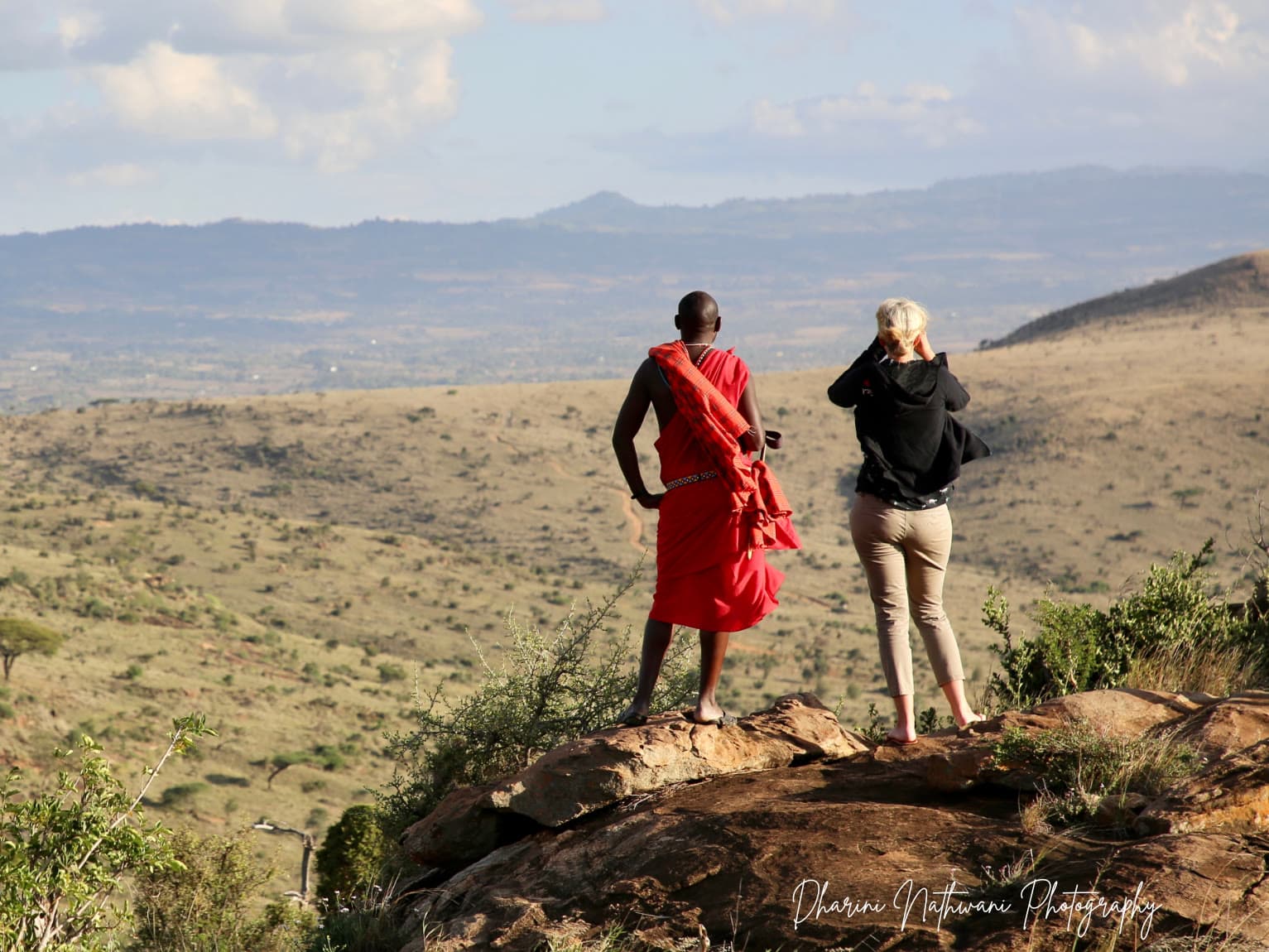 Juliet and a Maasai guide looking out over the Mara from a rocky outcrop